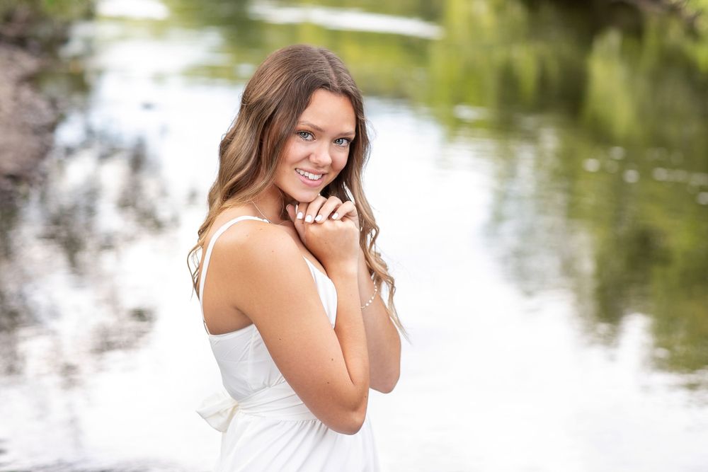 Portrait session near water with natural lighting and blurred background.