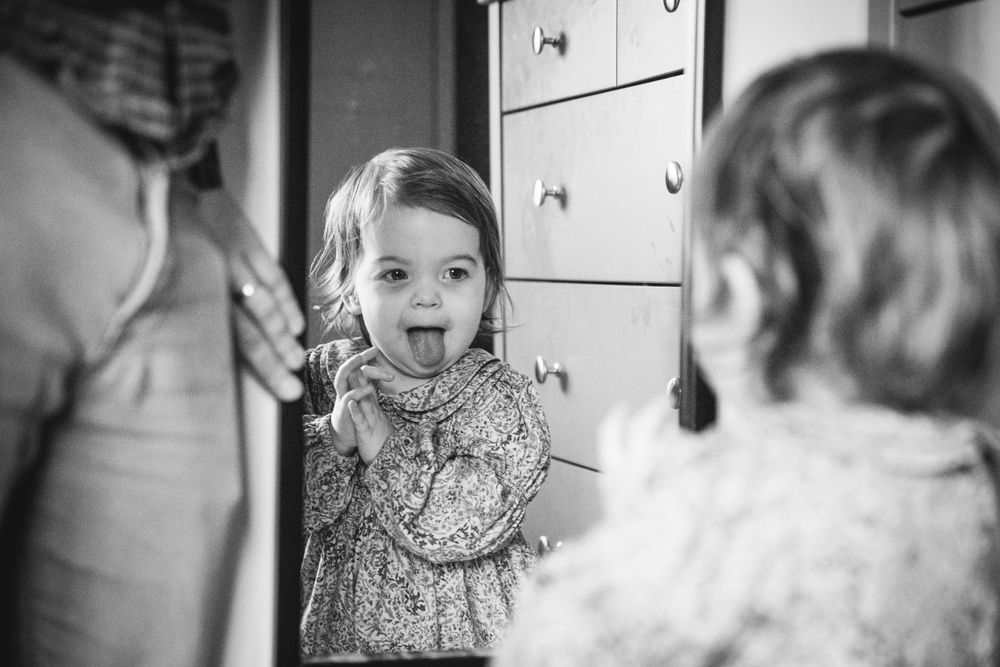 A joyful expression reflected in a mirror wearing a floral patterned dress.