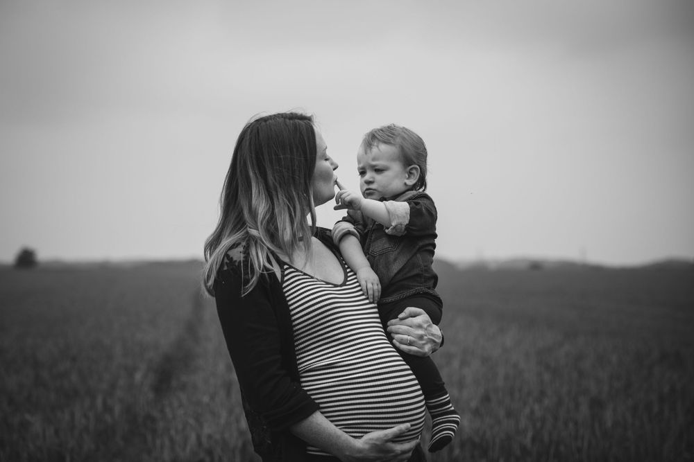 A heartwarming moment captured in black and white with a toddler in a field.