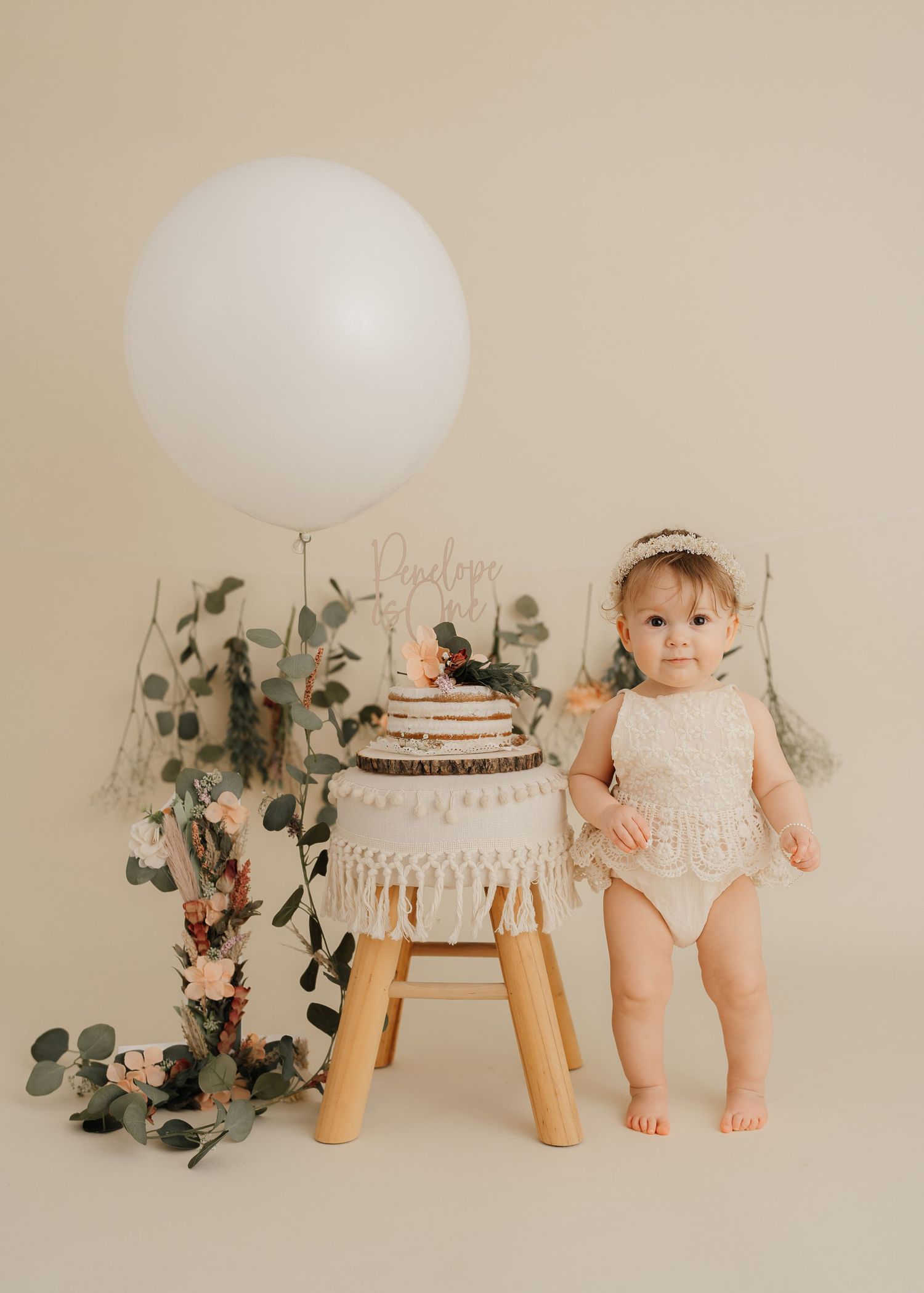 Modern minimalist baby photo with balloon, macrame decor and eucalyptus.