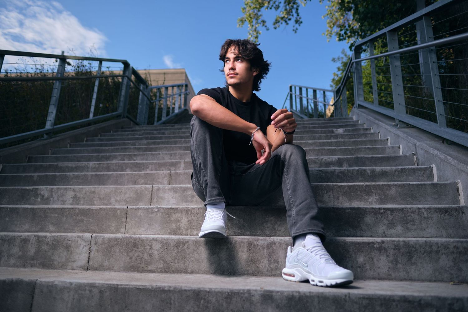 Appleton senior photo of a high school senior sitting on a staircase looking to the left of the frame.