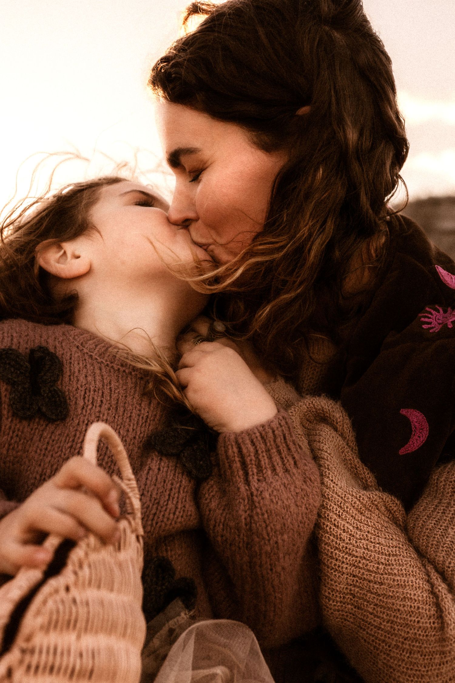 A tender moment in Javea shared with cozy sweaters on a winter's day in warm sepia tones - Javea Family photographer
