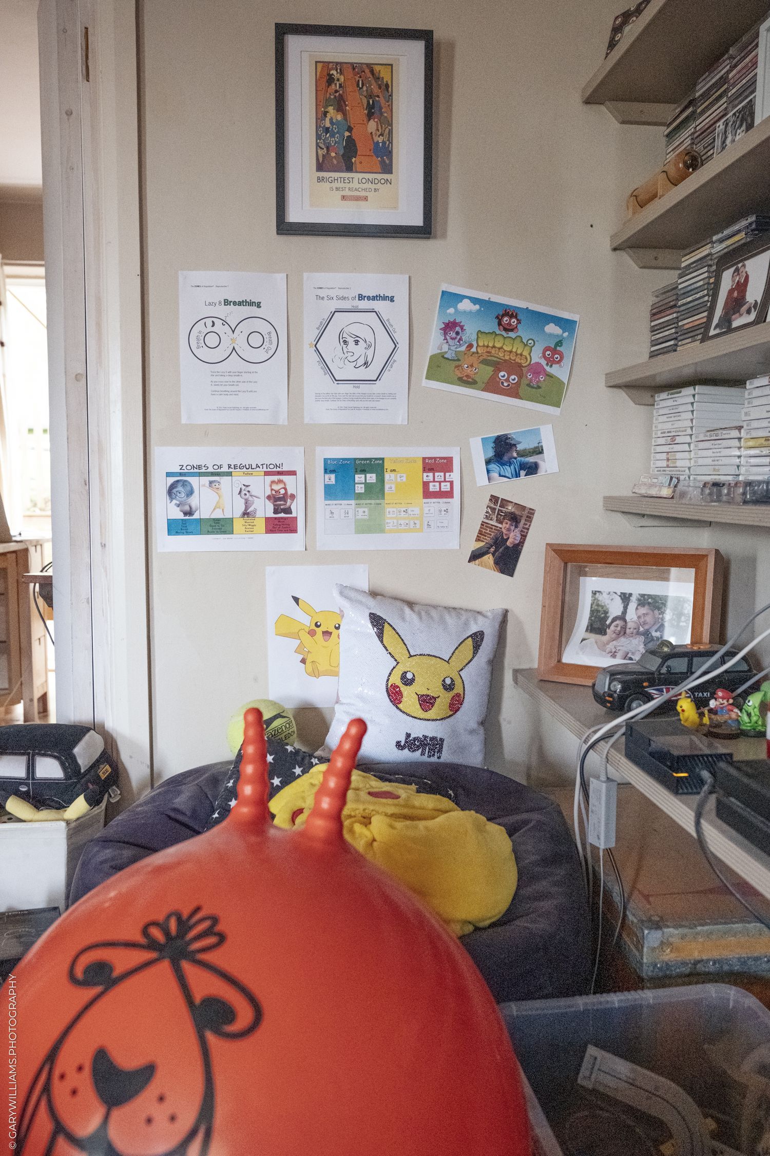 A Pokemon-themed room corner with Pikachu pillow, plush toys, wall art and decorations on floating shelves.