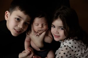 Siblings posing together during indoor studio portrait session with dark background.