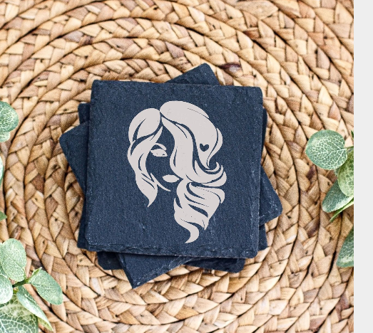 Decorative slate coaster with female silhouette design on woven mat with eucalyptus leaves.
