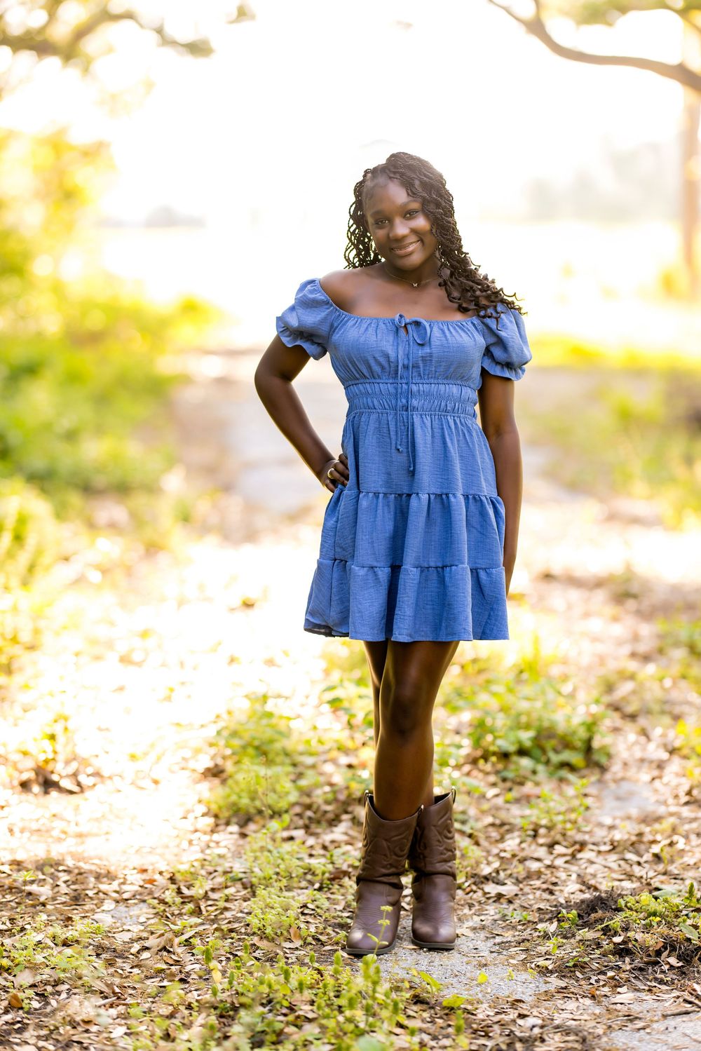 A stylish outdoor portrait in a tiered blue dress and brown boots.