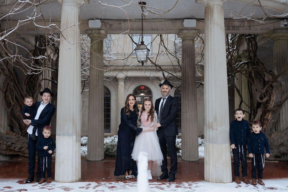 A celebration takes place under a columned portico entrance during winter.
