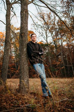 Boy leaning against tree for senior session photography. Captured by Maryland Photographer Mallory Bramlett.