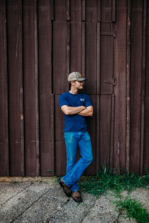 Boy standing in front of barn for senior session photography. Captured by Maryland Photographer Mallory Bramlett.