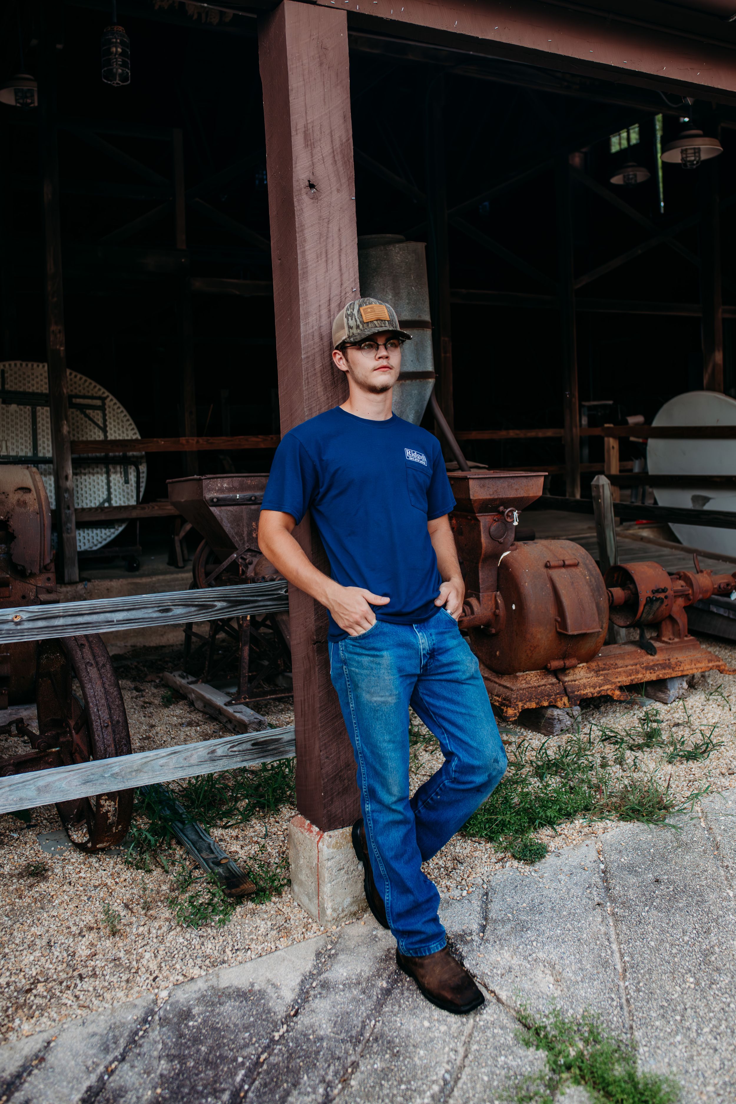 Boy leaning against barn for senior session photography. Captured by Maryland Photographer Mallory Bramlett.