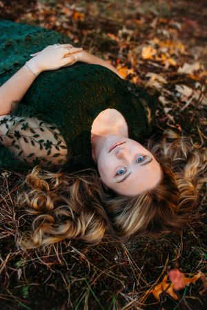 Girl lying in field looking at camera for senior session photography. Captured by Maryland Photographer Mallory Bramlett.