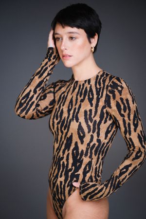 Close-up fashion shot of textured tiger stripe garment against dark background.