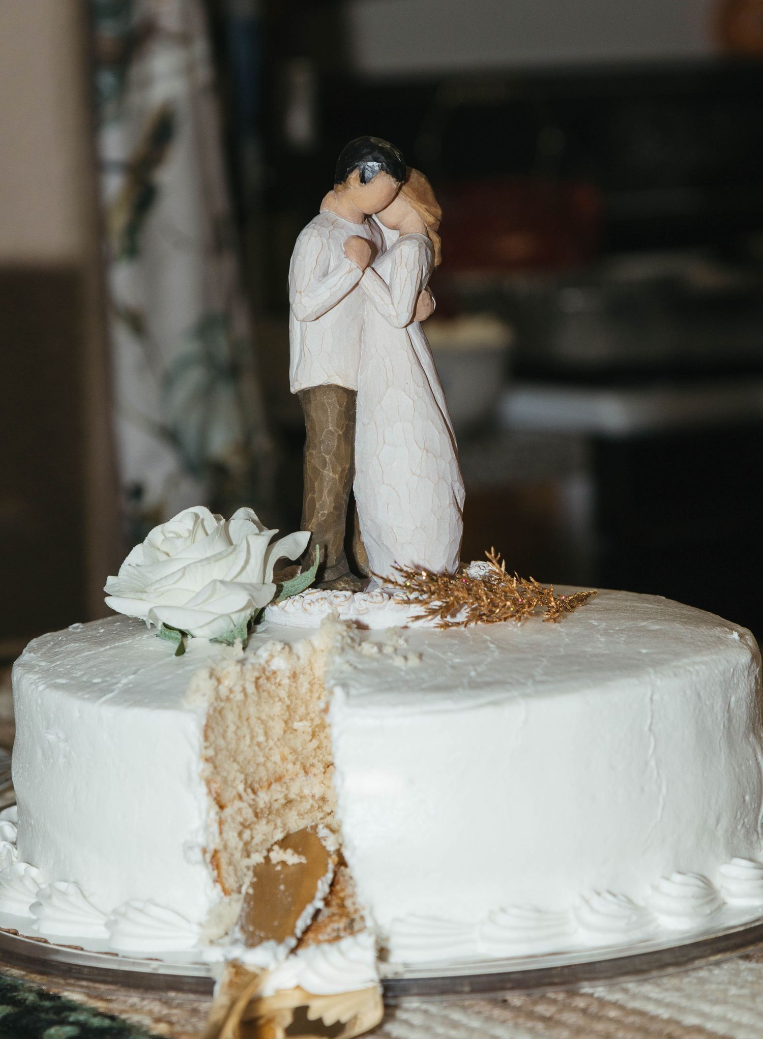 A flowing white wedding dress glows in soft sunlight beneath trees in a dreamy garden setting.