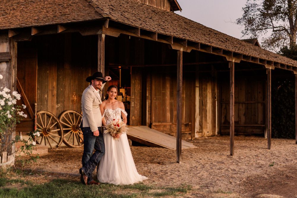 Rustic barn wedding venue exterior with wooden beams and natural lighting.