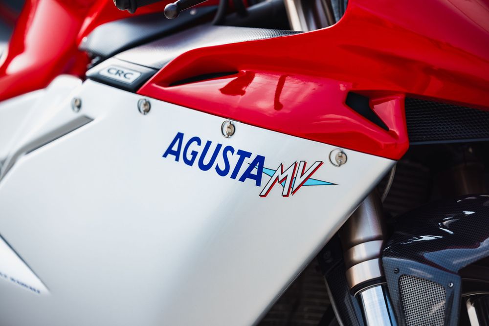 Close-up view of an Agusta MV sport motorcycle showing red and white bodywork with Agusta branding.