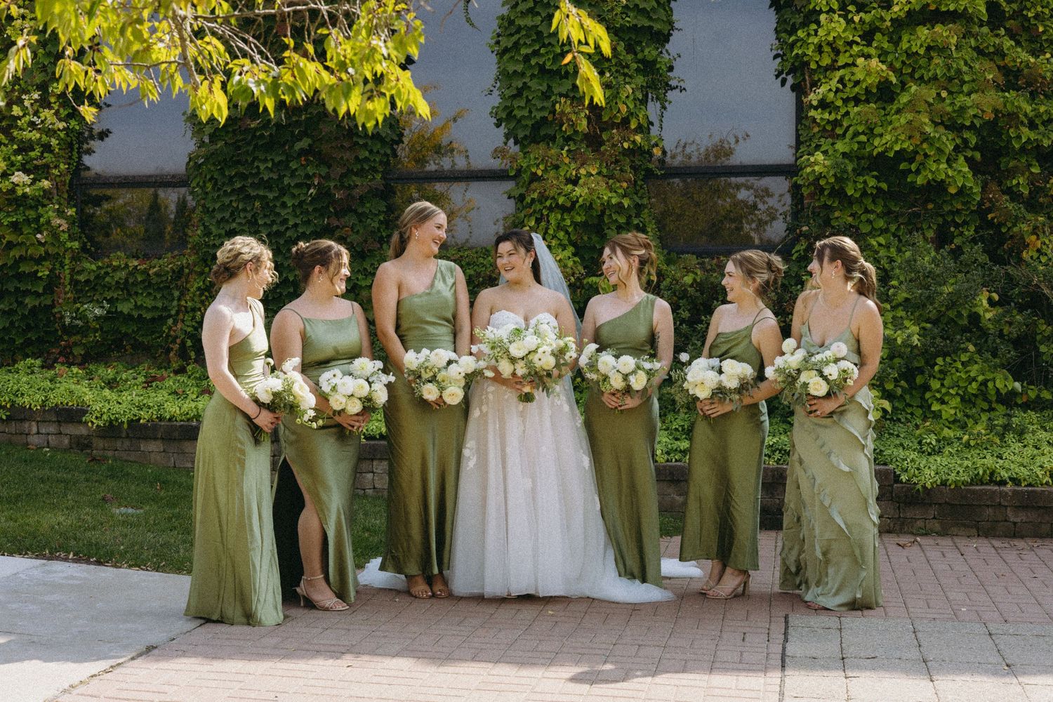 A bride and groom pose back to back while holding hands for a detail shot at their wedding showcasing their outfits.