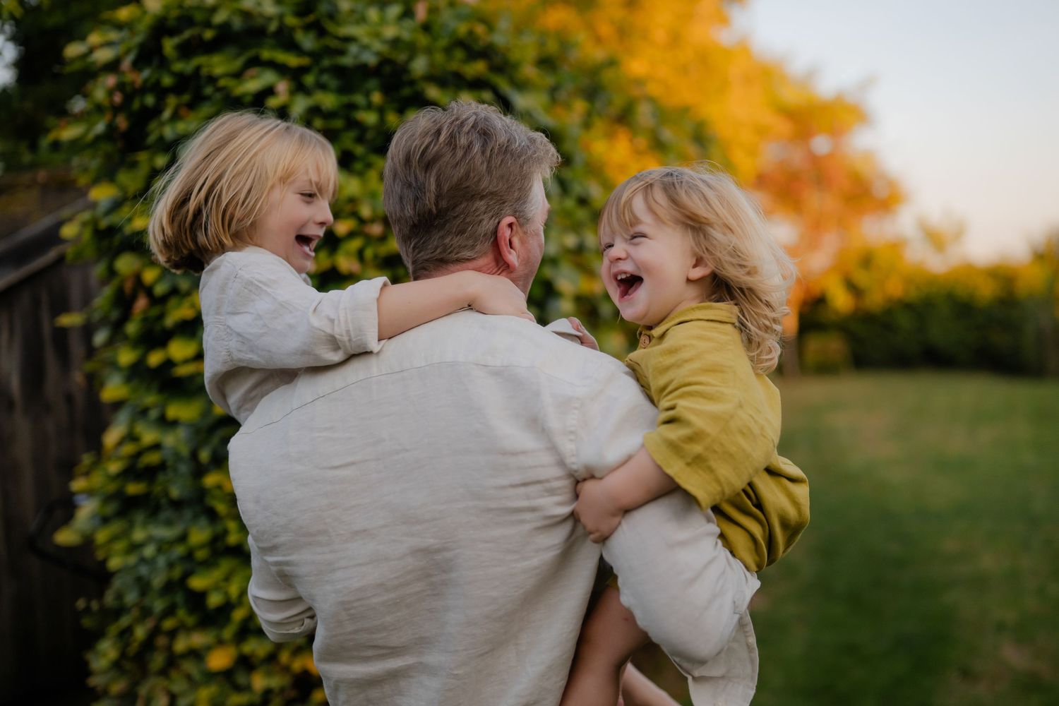 A dad swirling his two boys,  laughing during their photo session in Kent