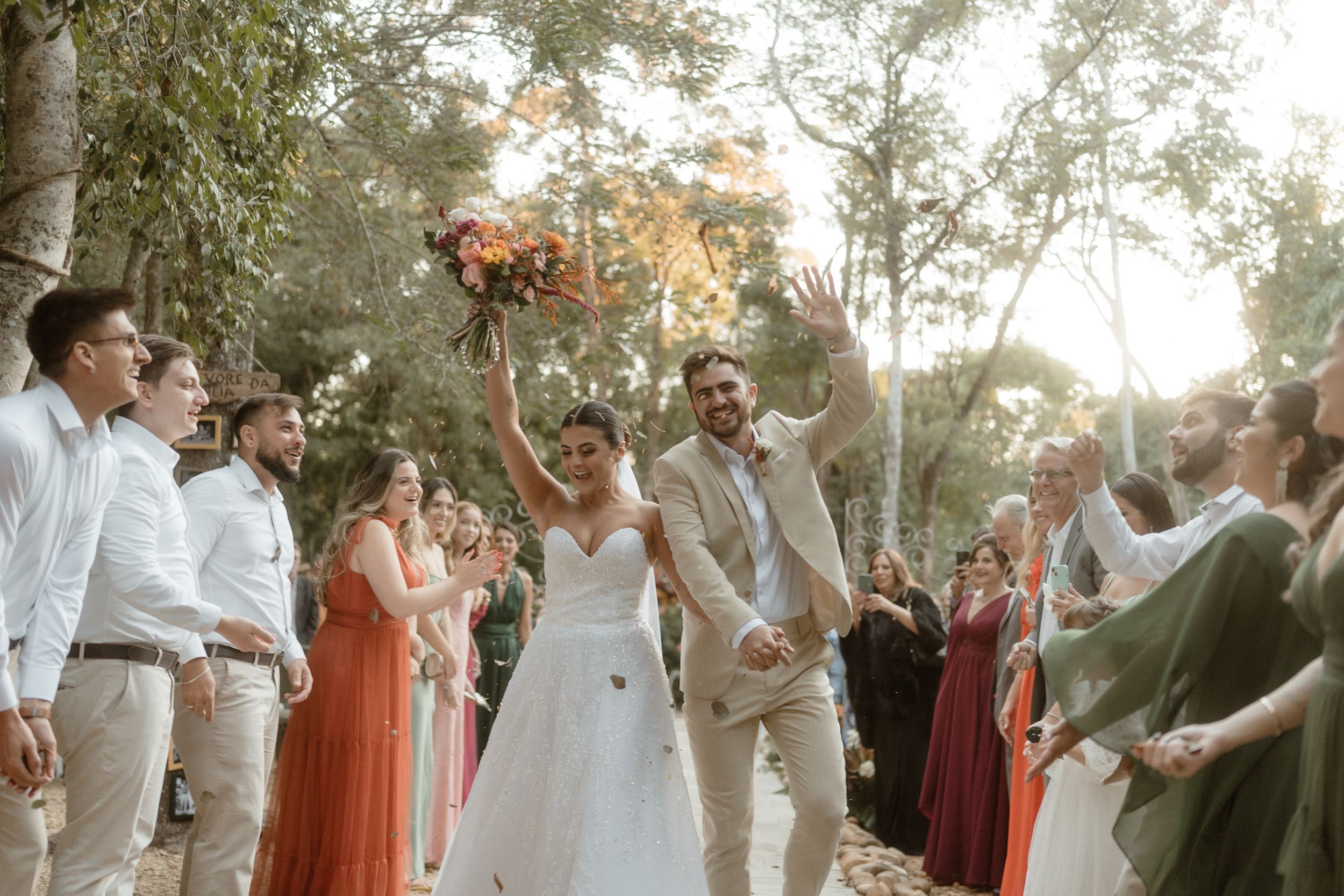 Wedding celebration in woodland setting with coral bridesmaid dresses and natural decor.