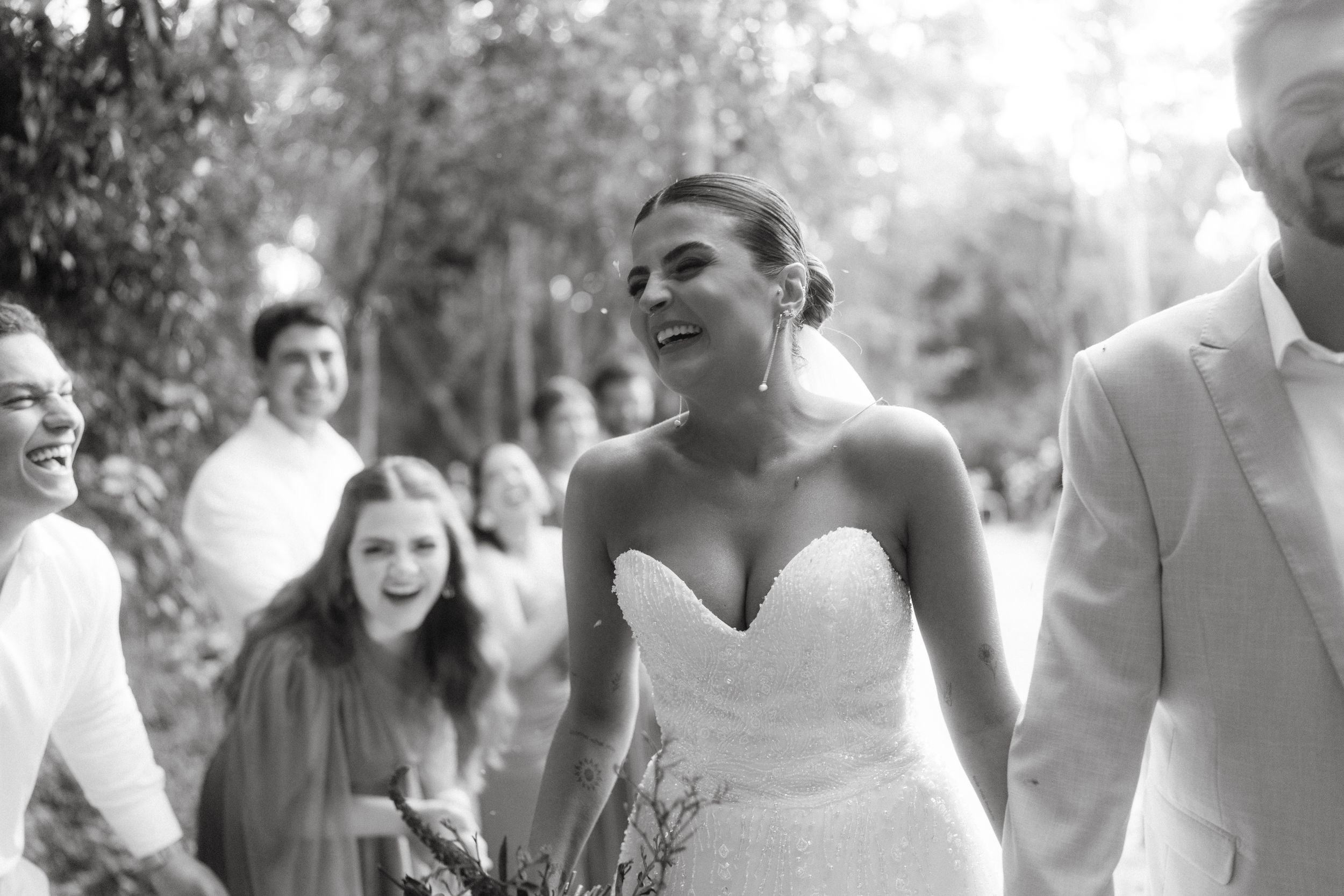 Black and white candid moments from outdoor wedding celebration.
