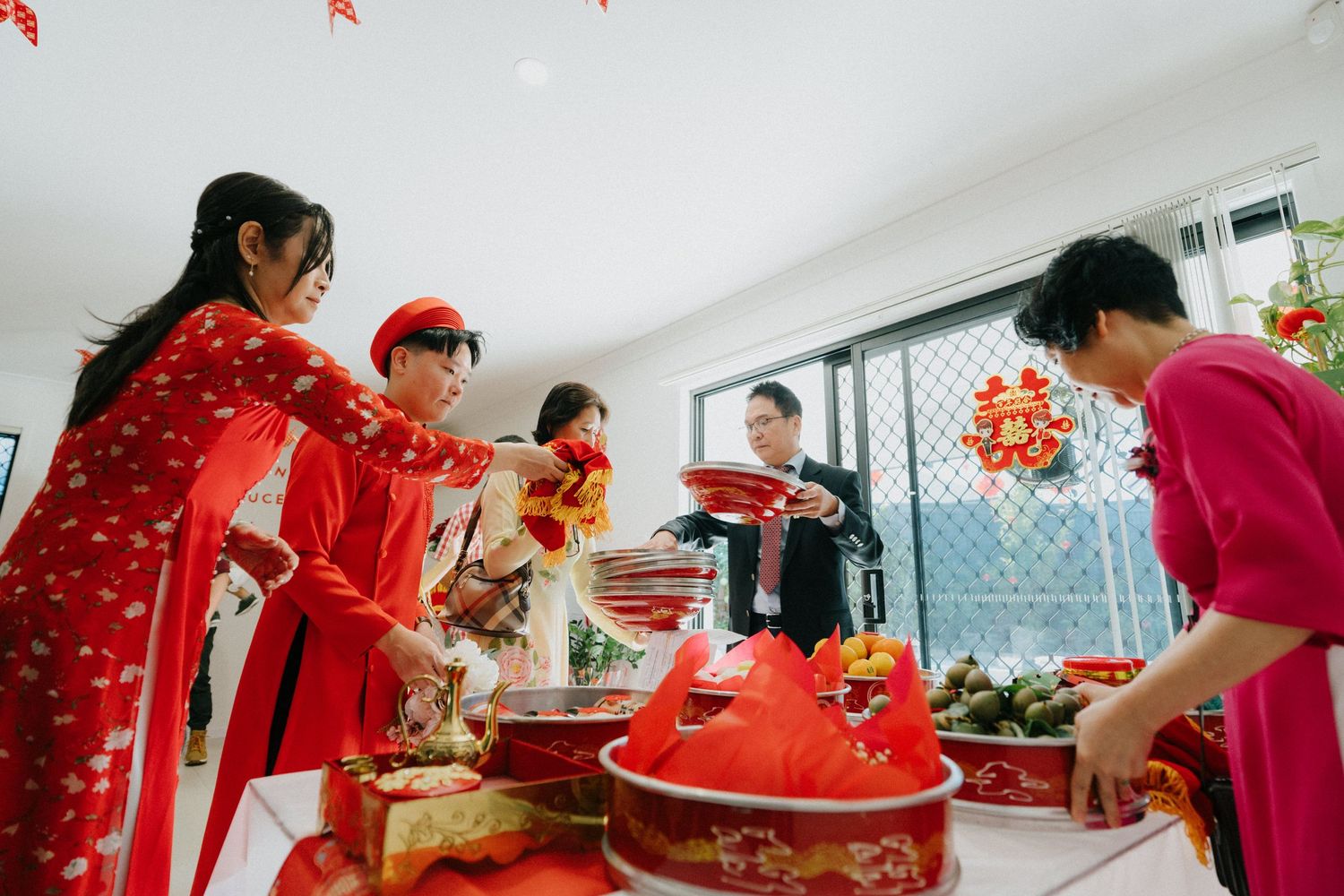"Tea ceremony at wedding with bride and groom in traditional attire"