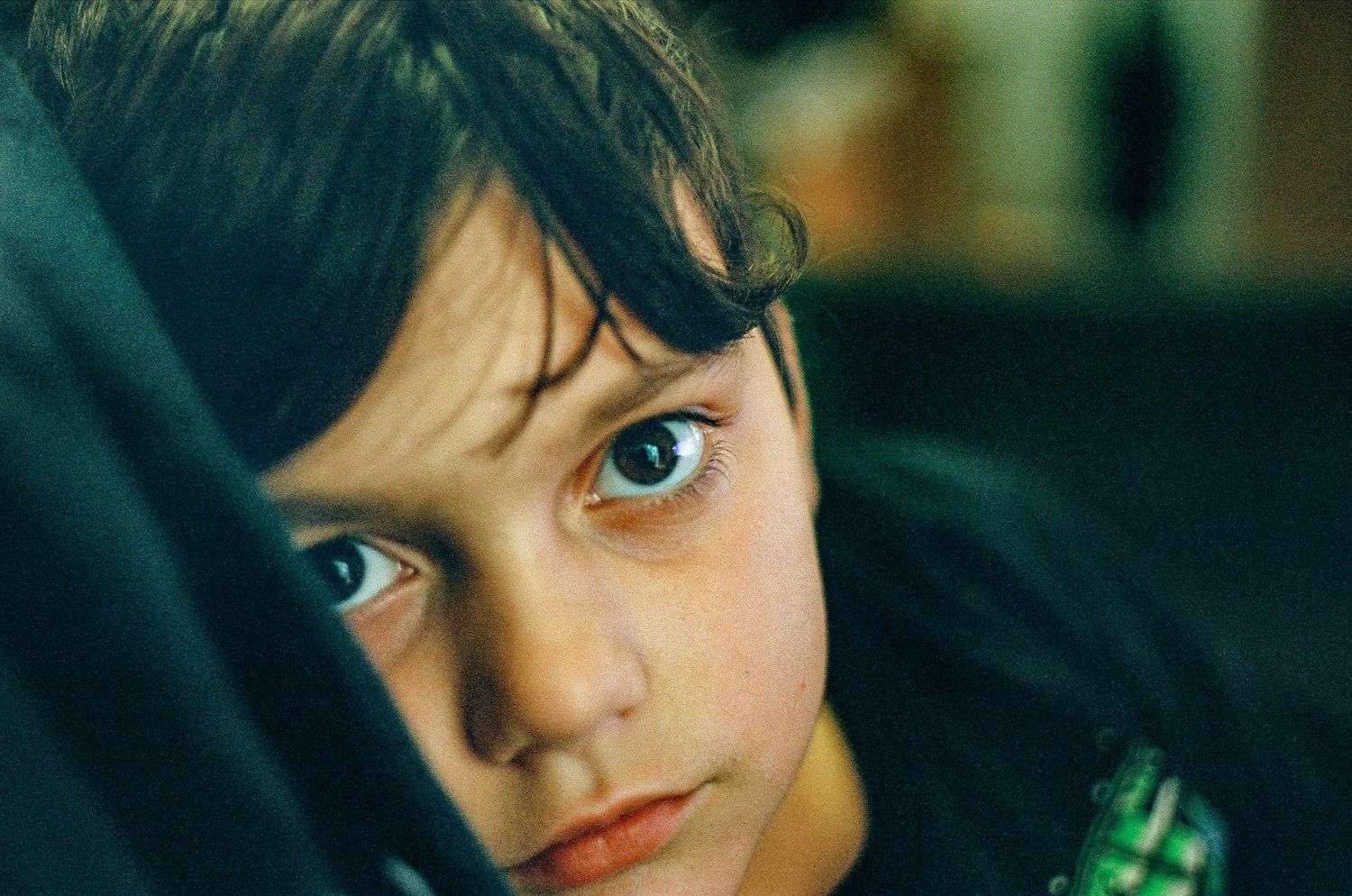 Close-up portrait showing striking blue eyes in dramatic lighting.
