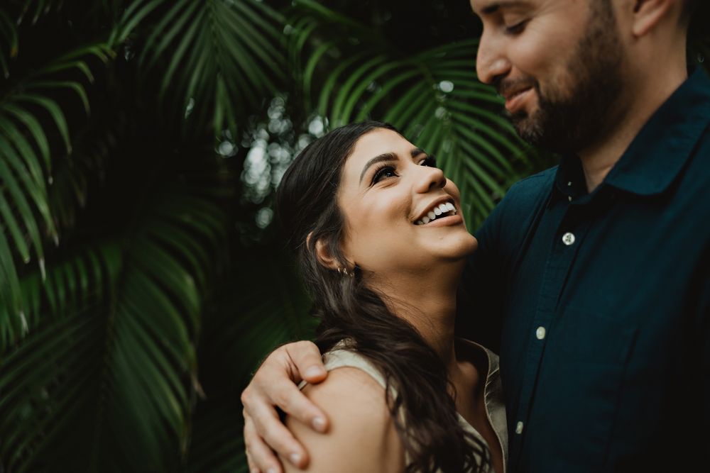 Bride smiling joyfully at her partner, radiating happiness in the coastal breeze