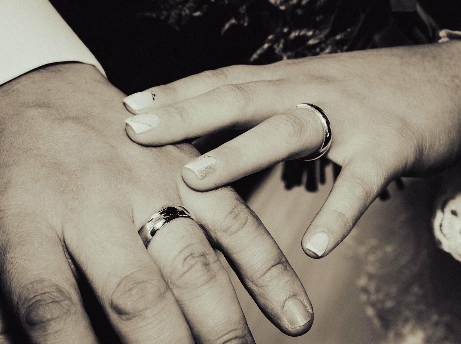A close-up sequence of hands showing wedding rings being exchanged during a ceremony.