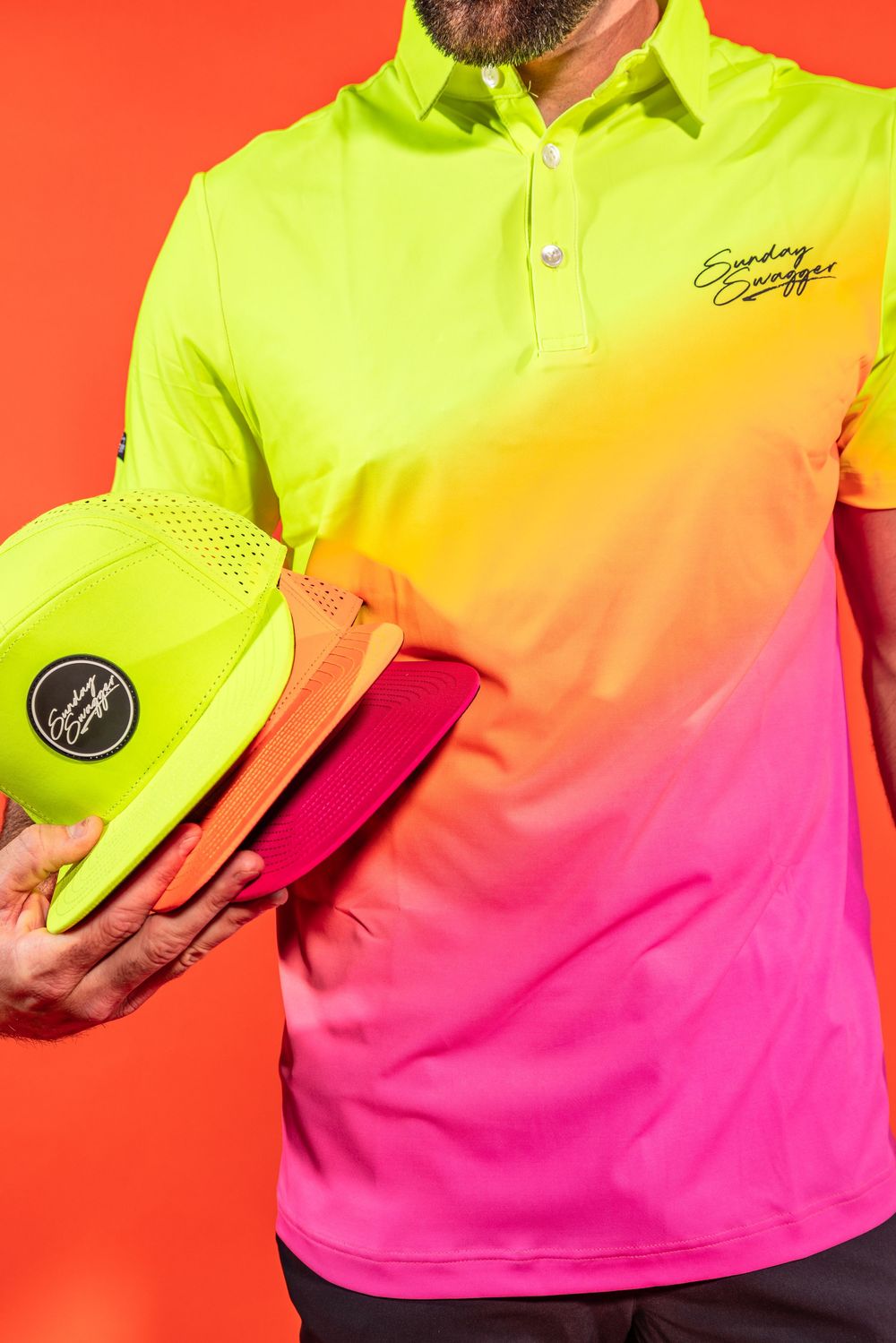Vibrant neon gradient polo shirt in yellow to pink with matching cap against red background.