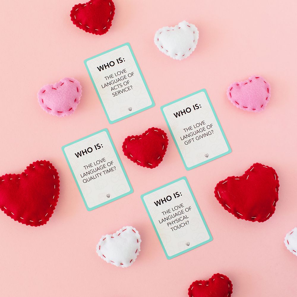 Red and white felt heart decorations with 'Who Is' game cards on pink background.