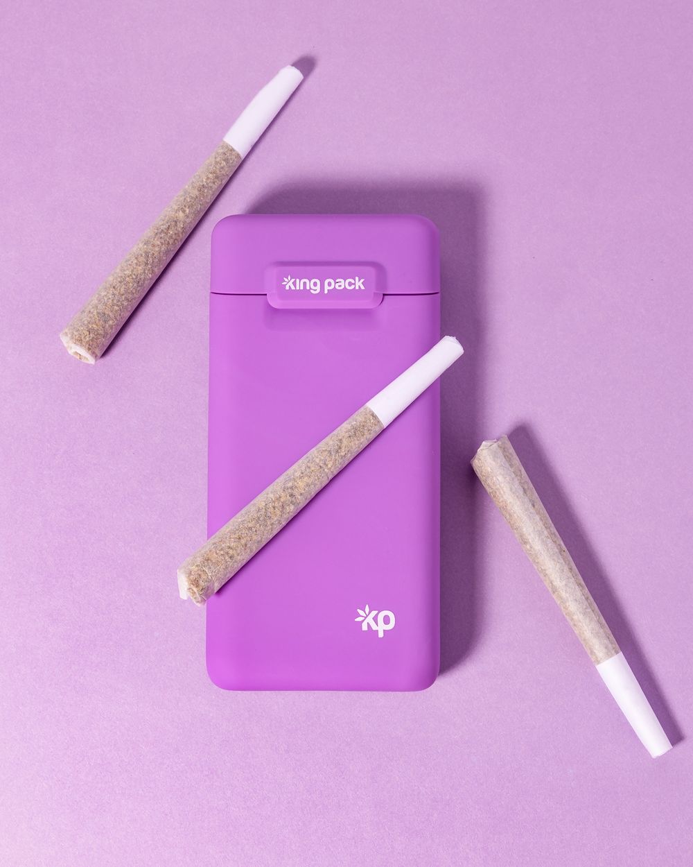 Purple vape device case with pre-rolls arranged on purple background in minimalist layout.