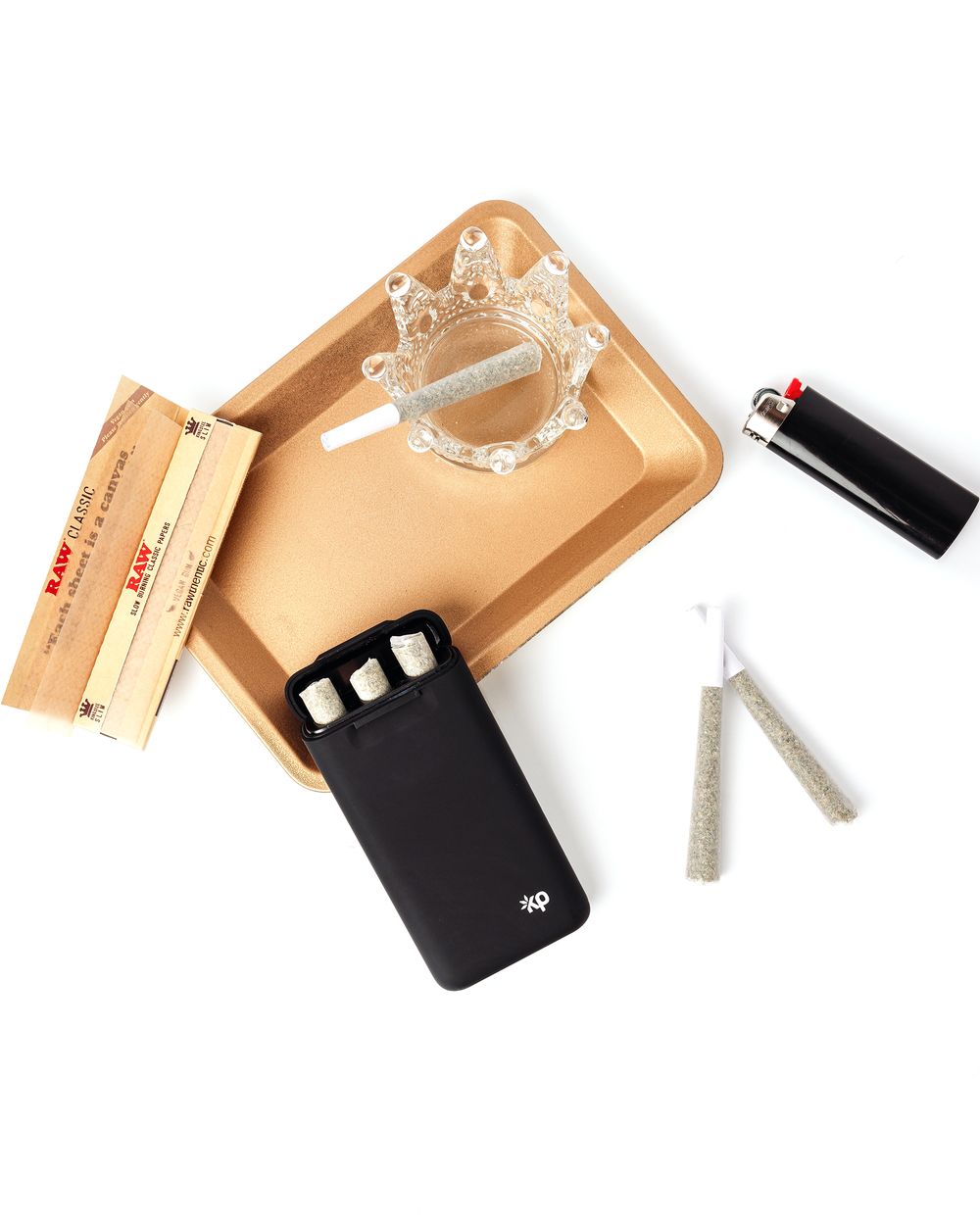 Smoking accessories including rolling papers and lighter arranged on wooden tray.