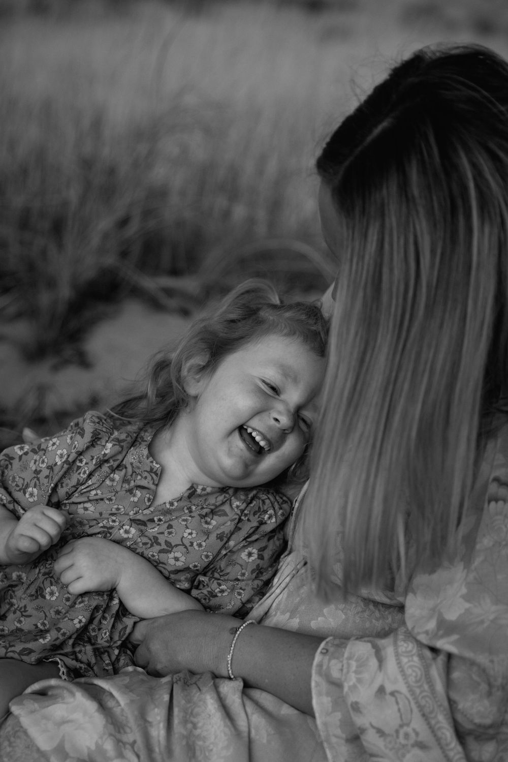 A heartwarming black and white photograph capturing a child's infectious laughter in a candid moment.