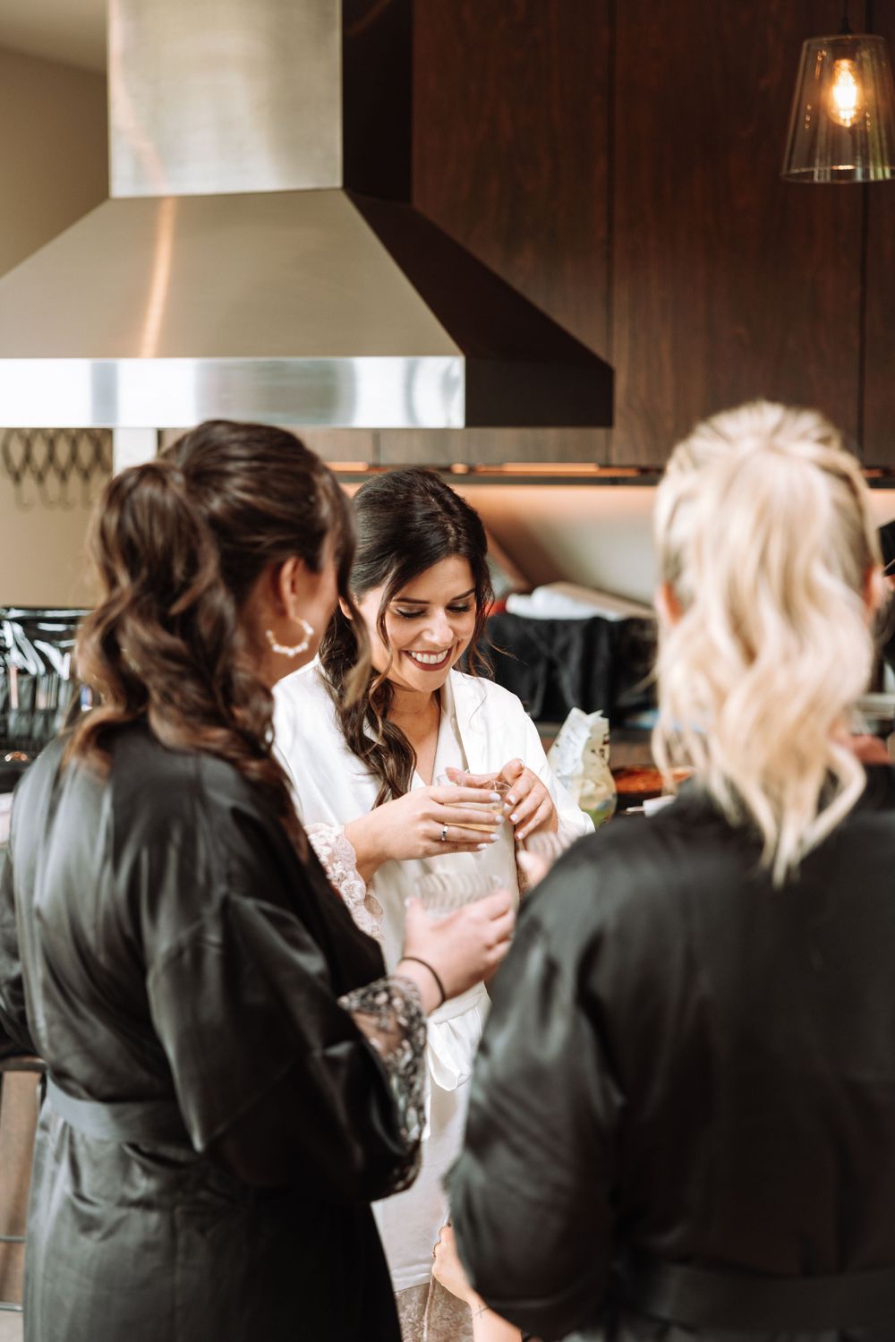 A group of women gather in a modern kitchen during a celebration.