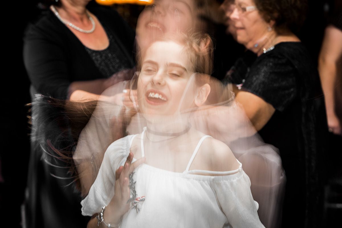 A long exposure shot captures a dancing bride in motion with blurred motion effects.