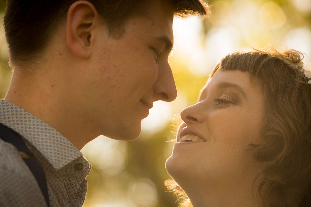 A romantic sunset moment between a couple in soft golden lighting.