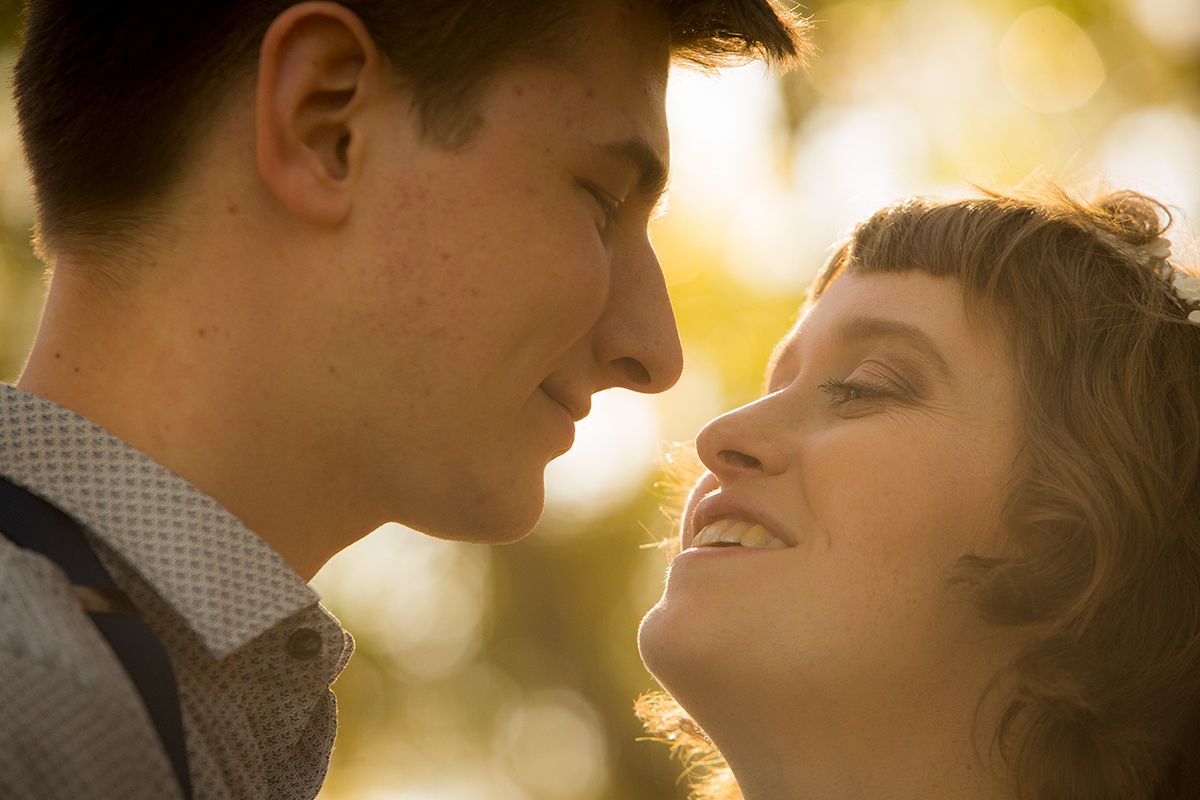A romantic sunset moment between a couple in soft golden lighting.