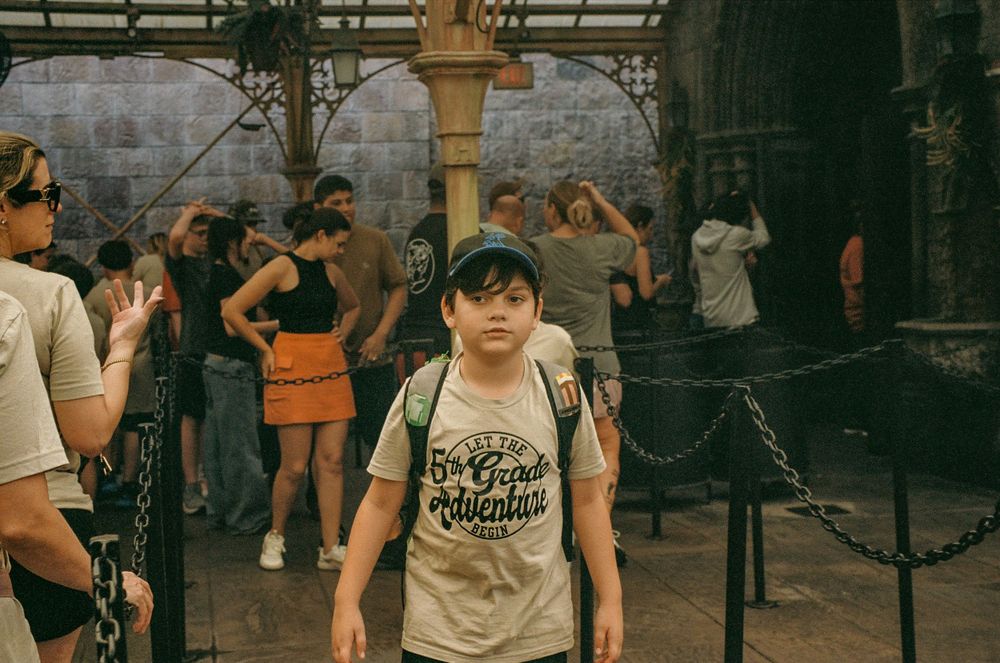 Visitors explore a themed area with stone architecture and medieval-style decorations.