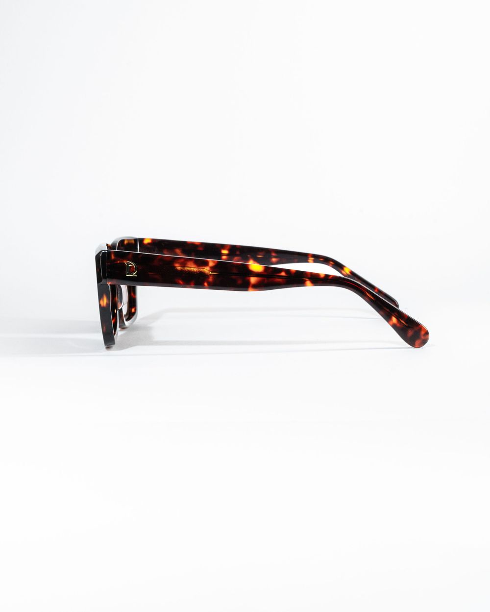 Side profile of tortoise shell pattern sunglasses displaying rich brown texture. Mtlshutter photography