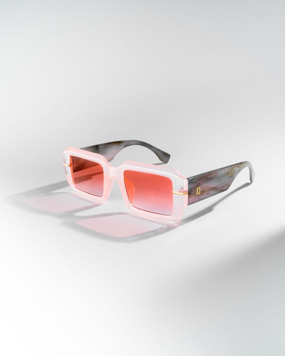 White rectangular sunglasses with pink gradient lenses photographed on light gray background. Mtlshutter photography