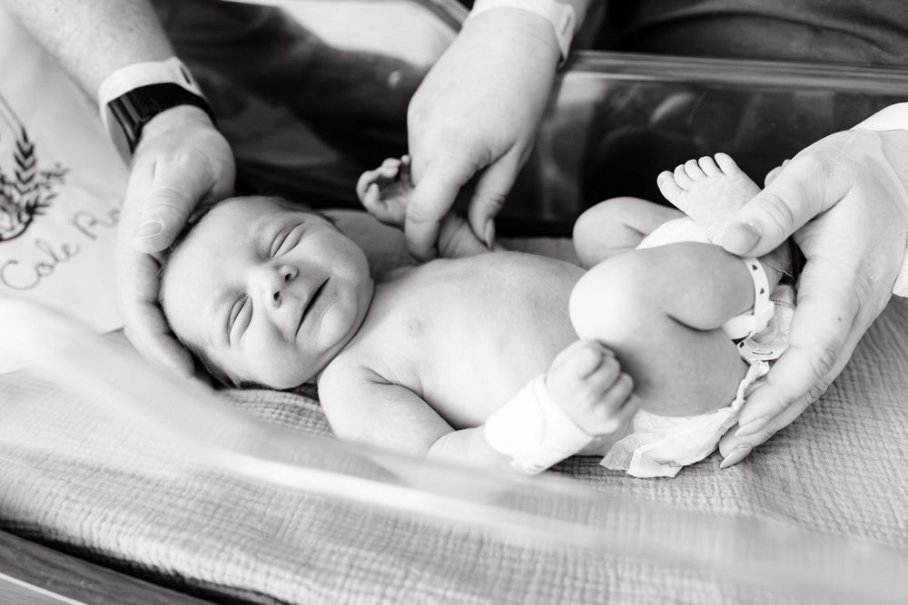 A series of black and white medical photos showing a baby getting examined and measured by healthcare professionals.
