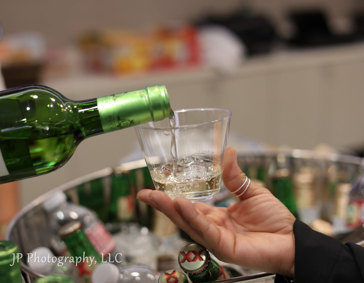 Hands pouring wine into glasses during a tasting event.