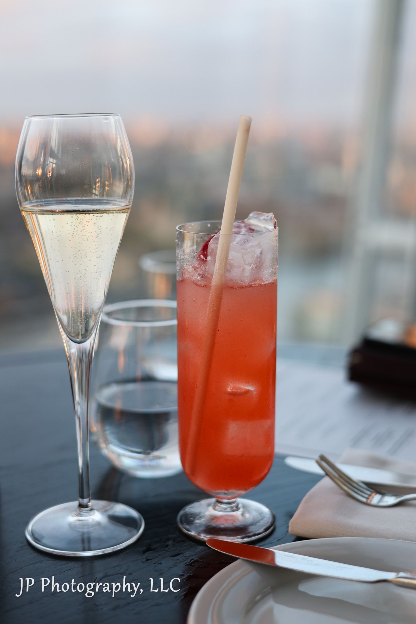 Elegant cocktail glasses with red drinks and champagne flutes on a restaurant table.