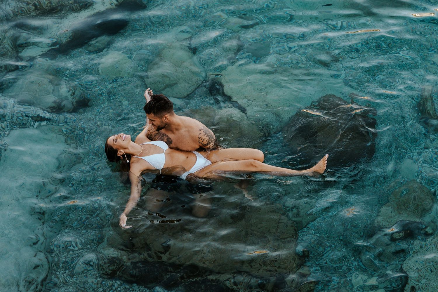 playful couple swimming in lake como during their Italy elopement