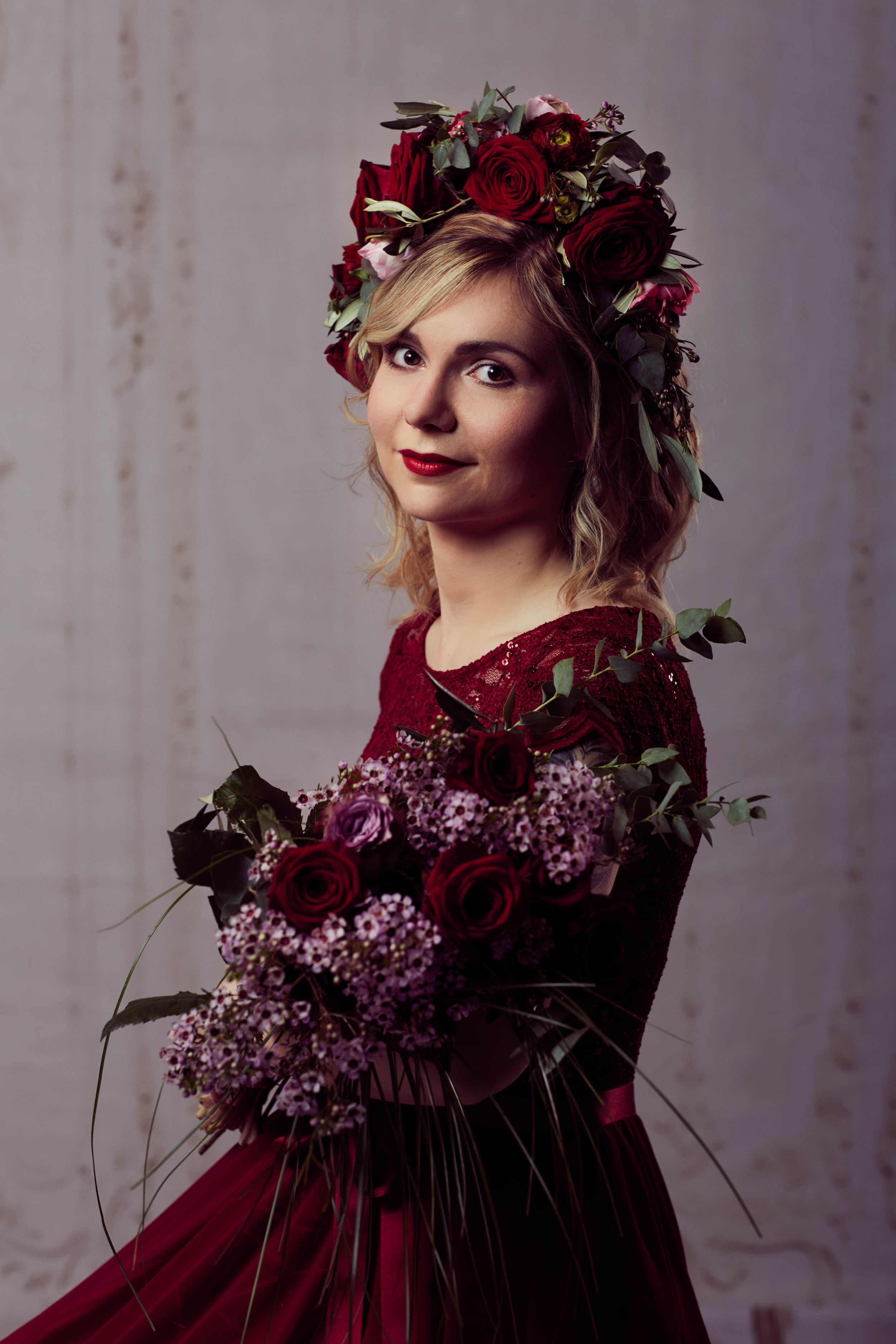 A woman dressed in crimson and flower accessories - don't believe what you see!