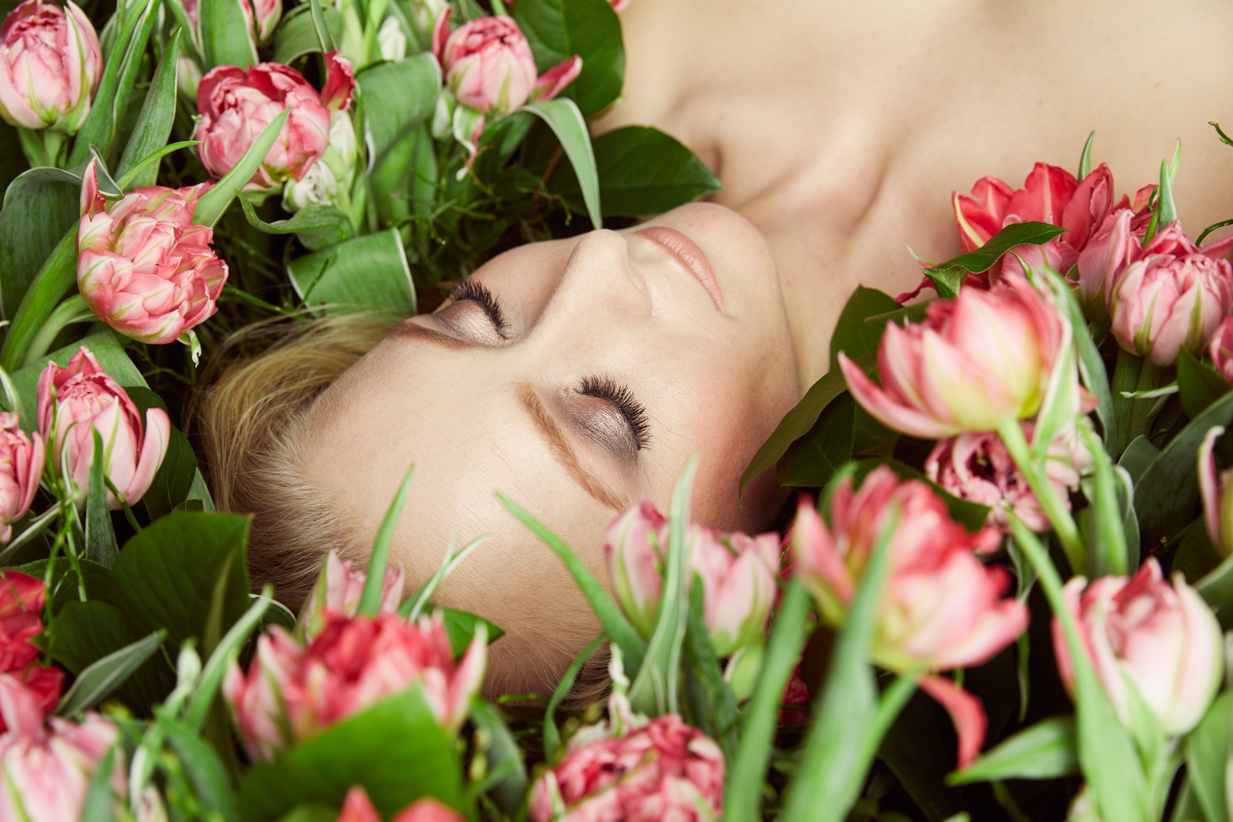 Woman lying on a bed of tulips