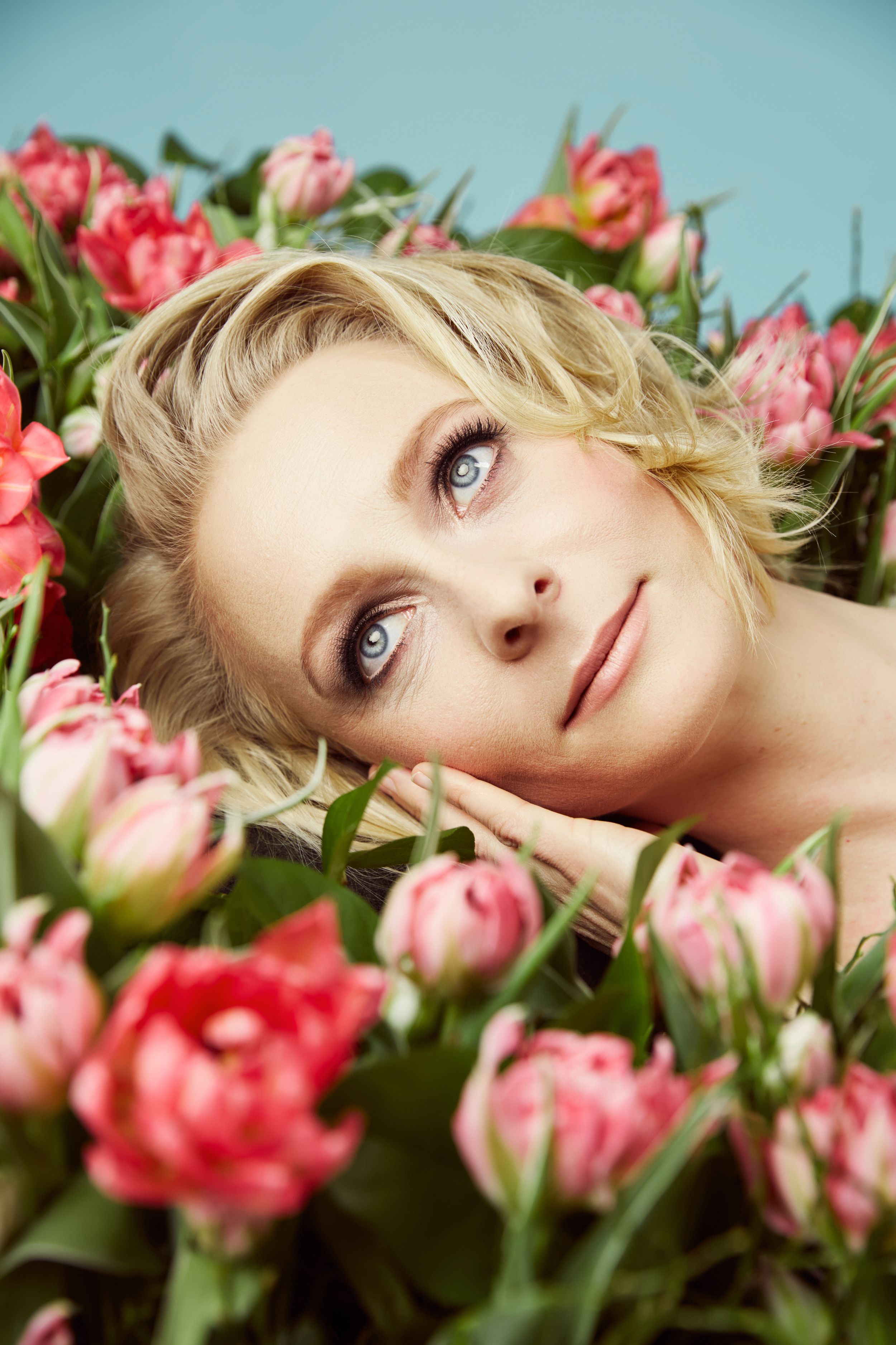 Woman day dreaming on a bed of tulips