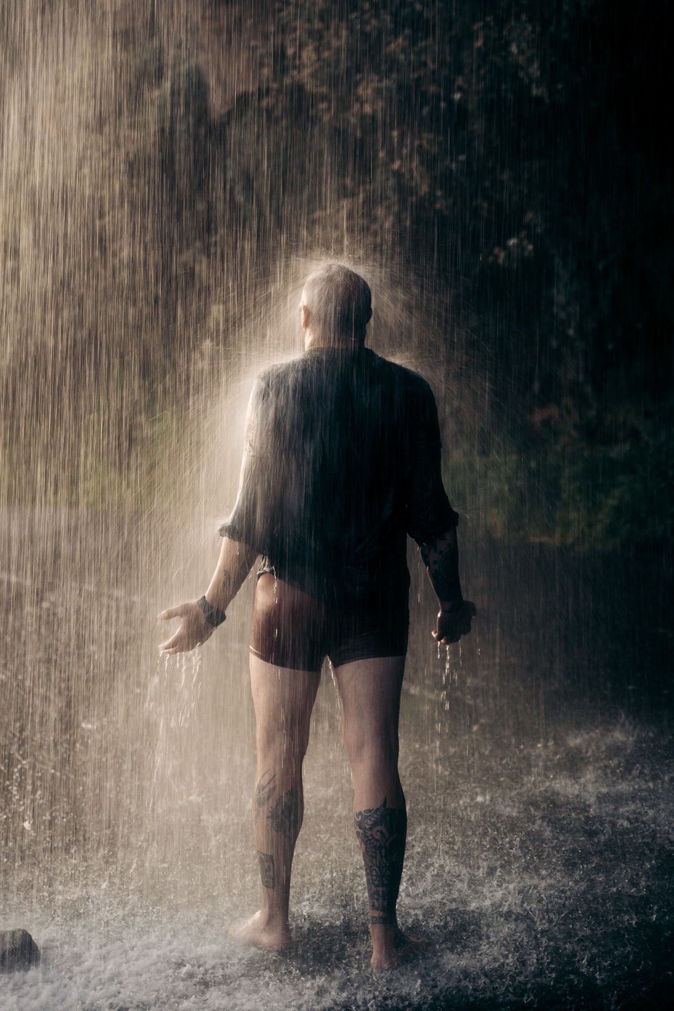 Homme sous la cascade dos anjos à Madère