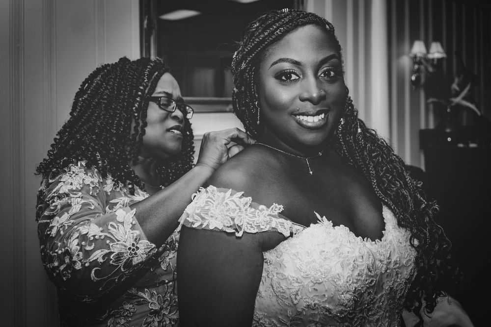 A heartwarming getting-ready moment captured in black and white during wedding preparations.