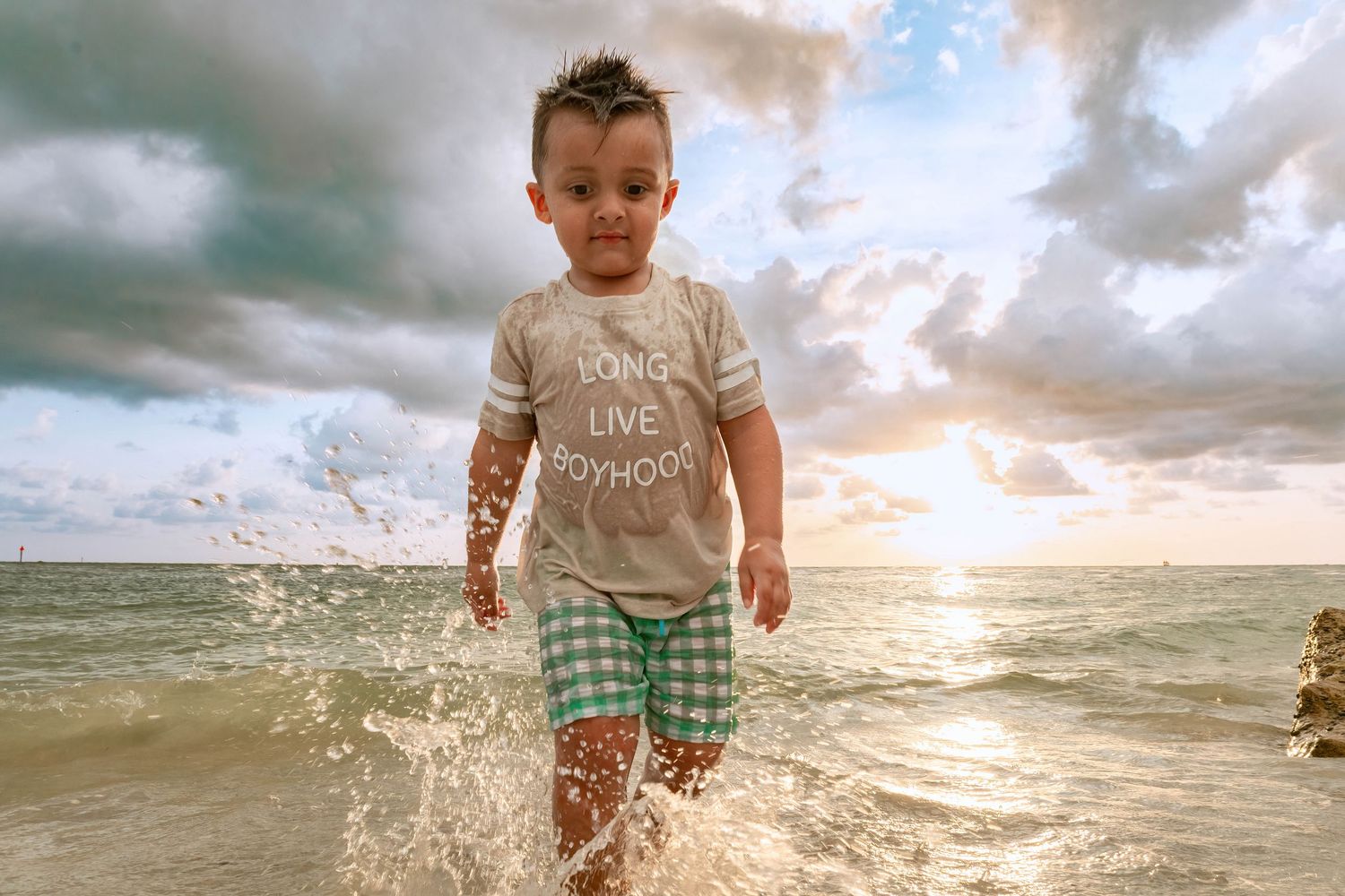 Water splashes at the shoreline during a golden sunset at the beach.