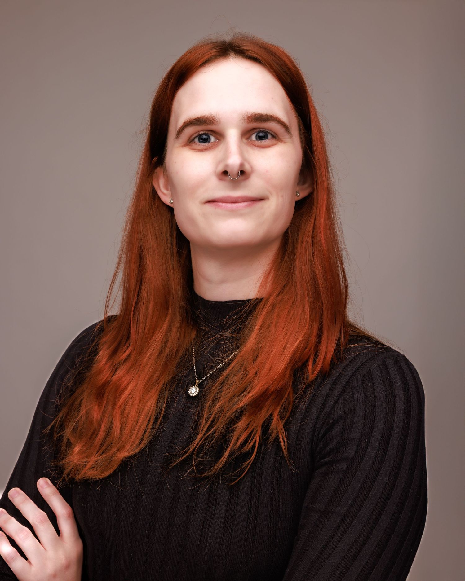 Portrait series showing various expressions of a person with red hair wearing black.
